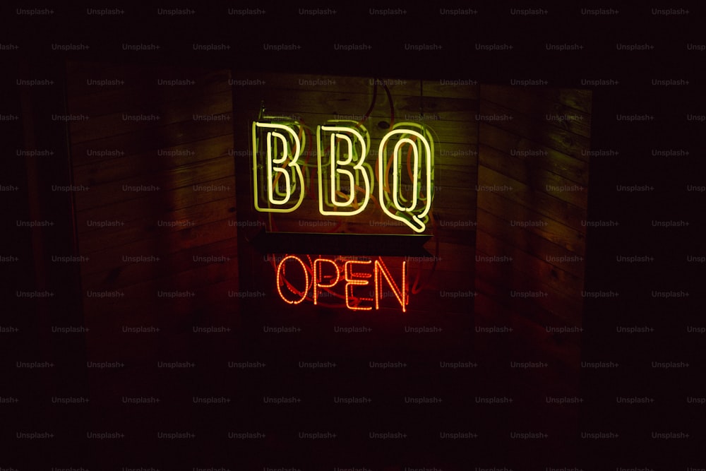 a neon sign that says bbq open in a dark room