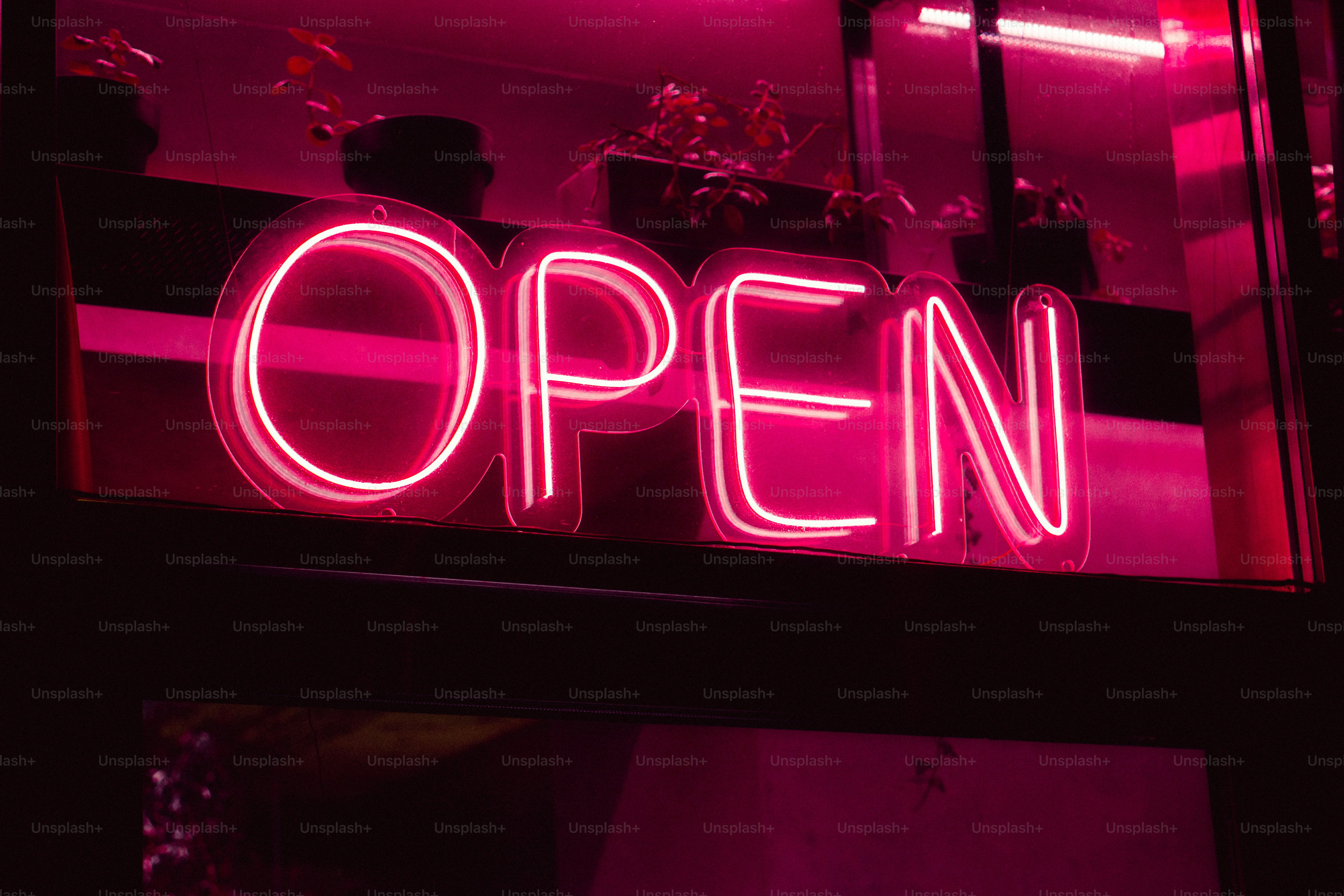 a neon sign that reads open above a window