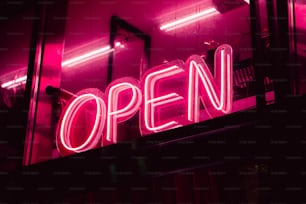 a neon sign that reads open in a window