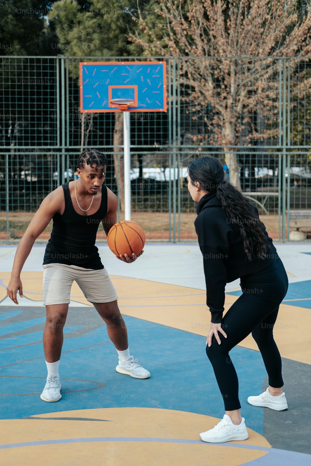 a man and a woman playing basketball on a court