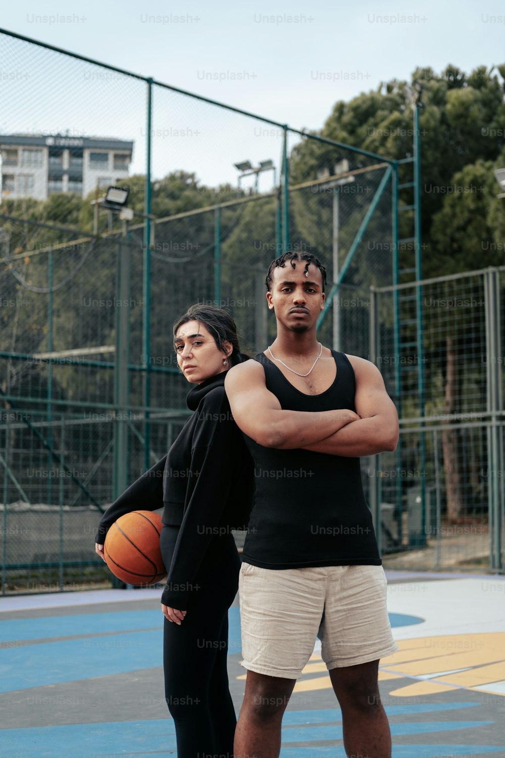 a man and a woman standing on a basketball court