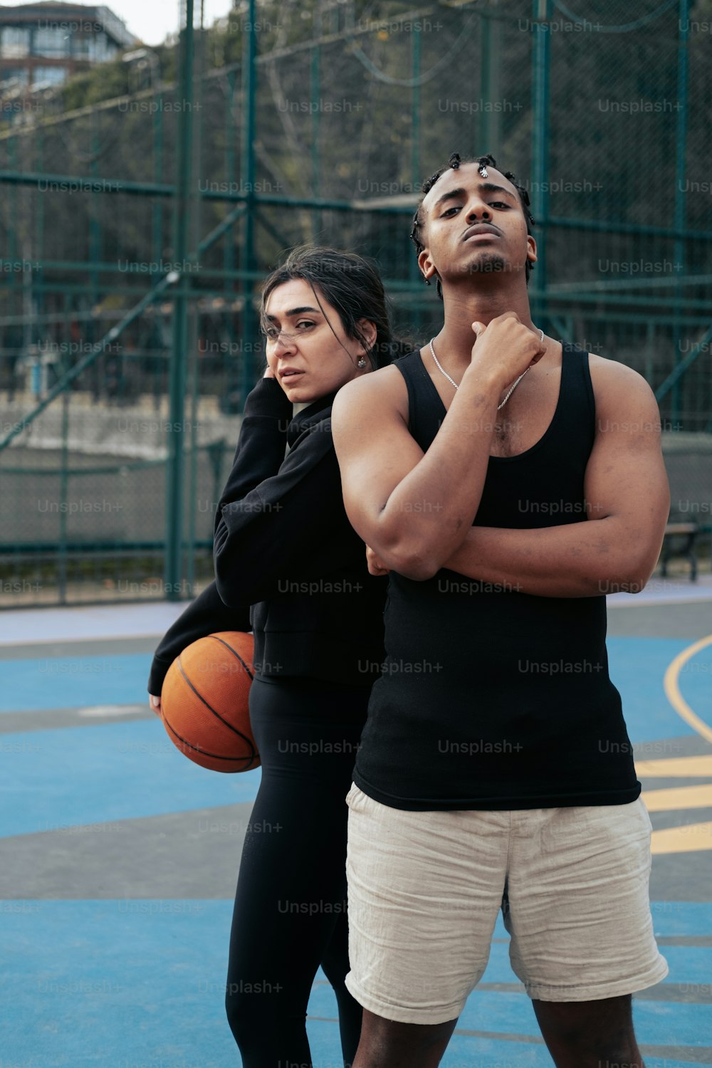 um homem e uma mulher em pé em uma quadra de basquete