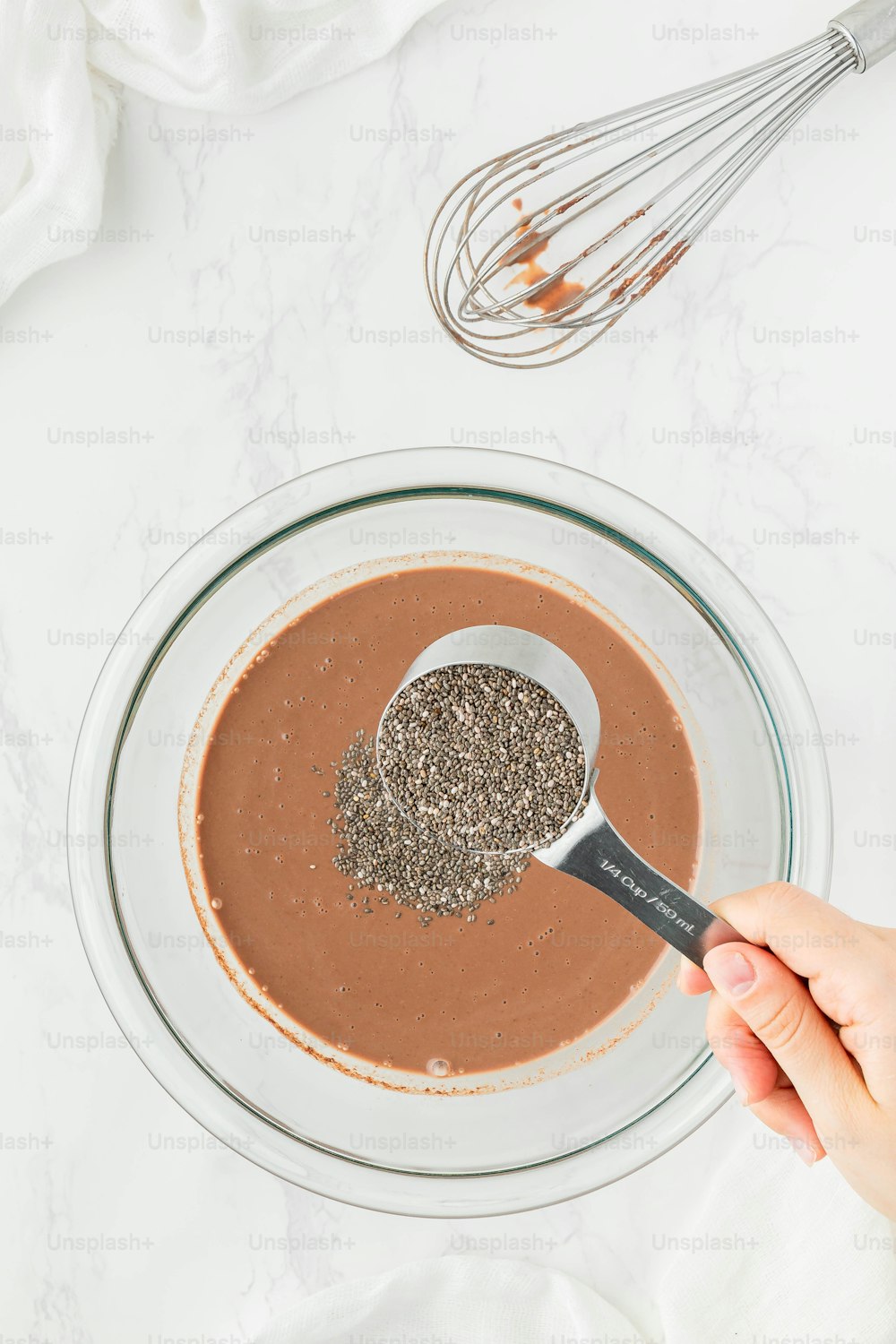 a bowl of chocolate pudding with a whisk in it