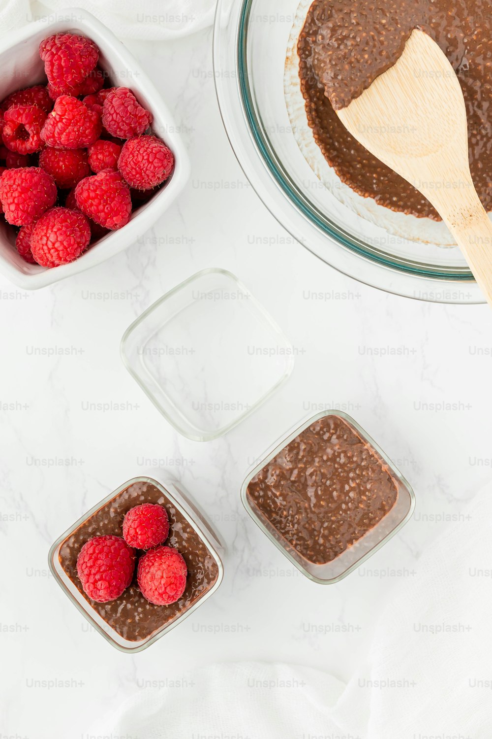 a bowl of raspberries and a bowl of chocolate pudding