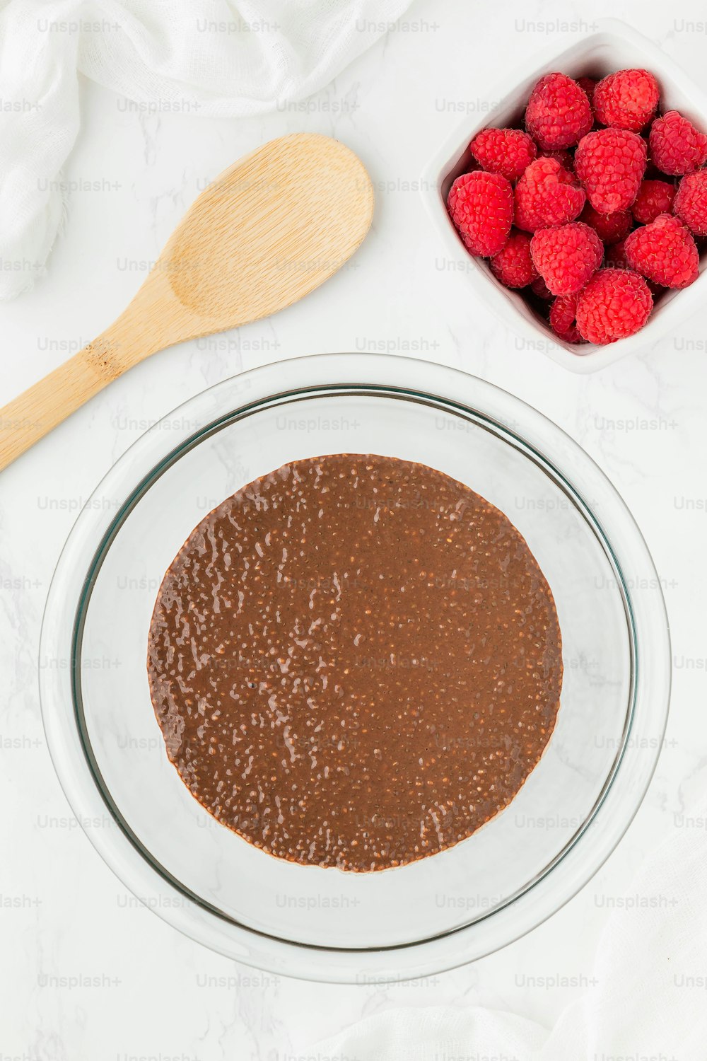 a bowl of chocolate pudding next to a bowl of raspberries