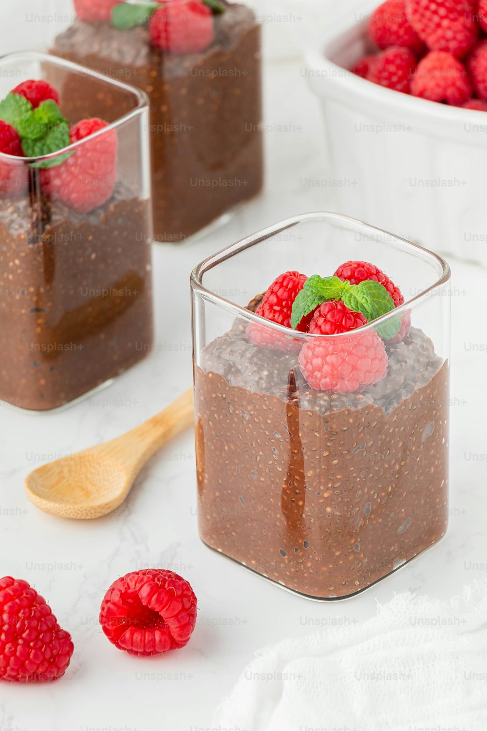 raspberries and chocolate pudding in small glass containers