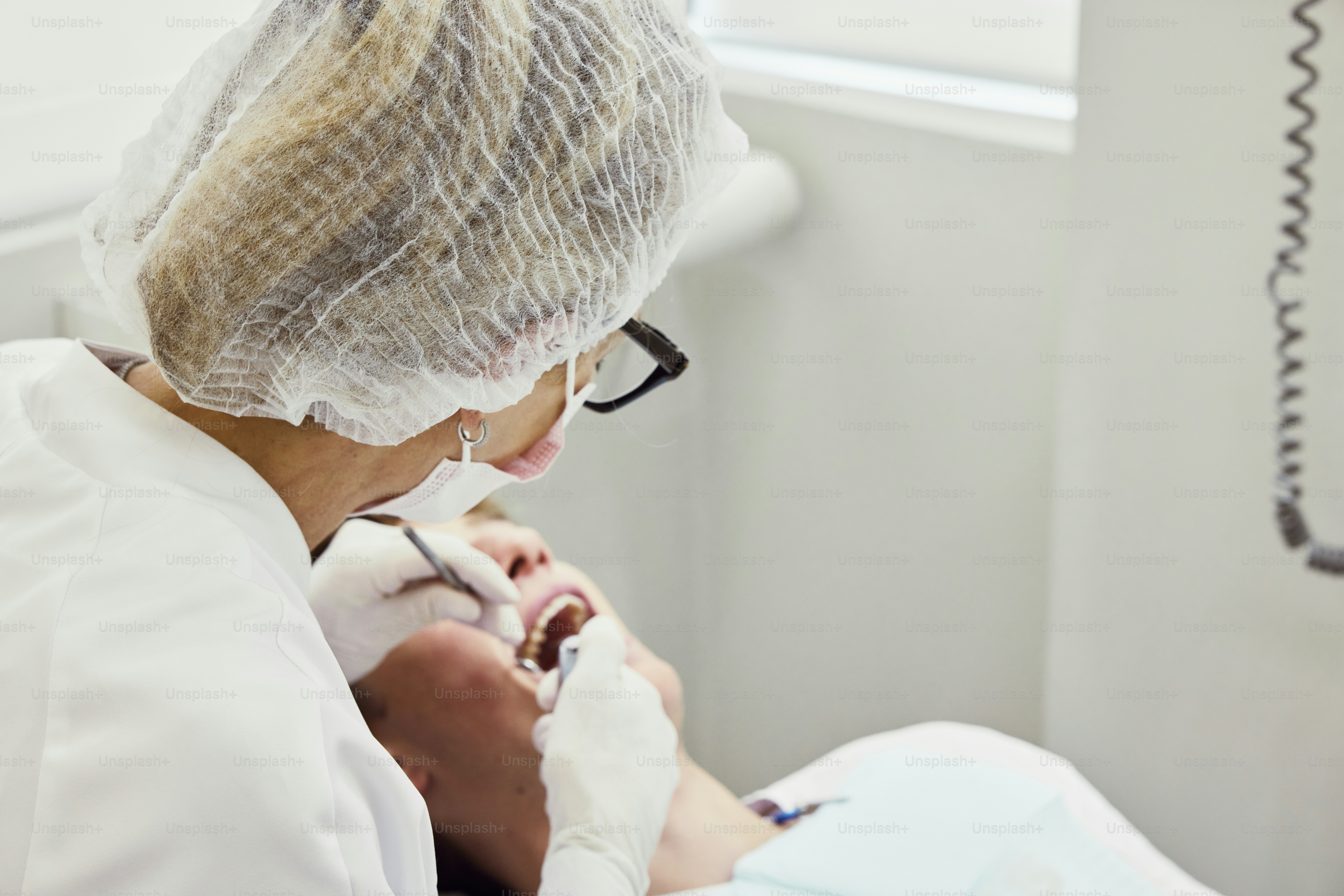 Una mujer que se revisa los dientes por un dentista
