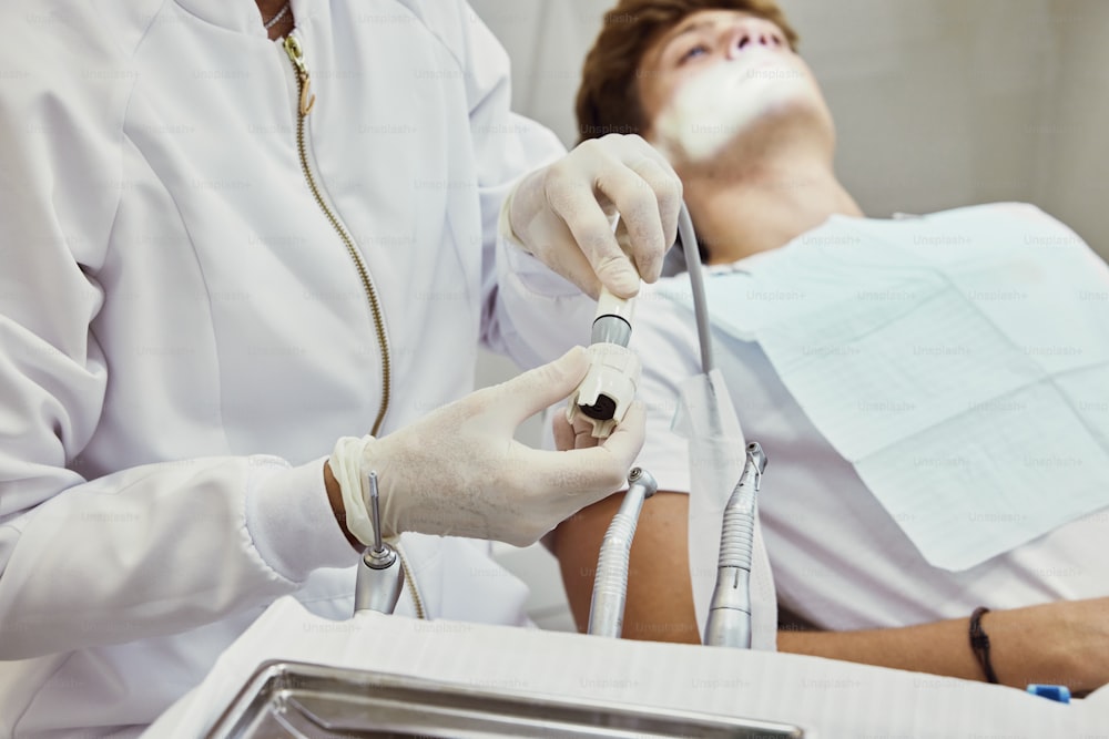 Un homme dans un lit d’hôpital se fait faire examiner les dents