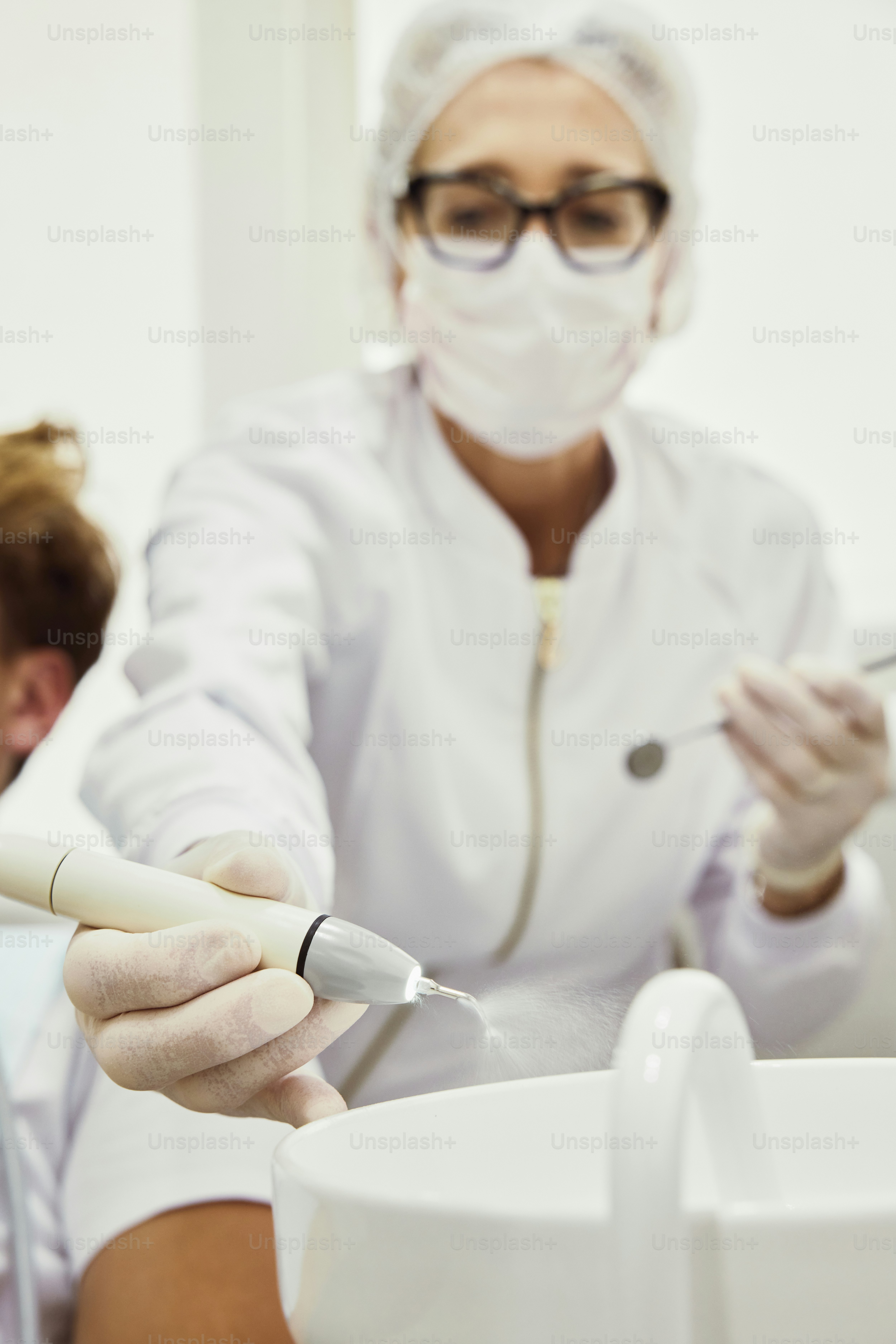 Una mujer con una bata blanca de laboratorio sostiene un cepillo de dientes