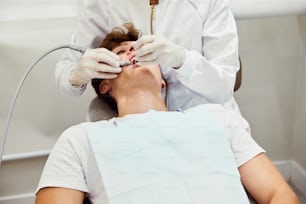 a man getting his teeth checked by a dentist