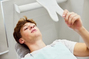 a man laying in a hospital bed holding a toothbrush
