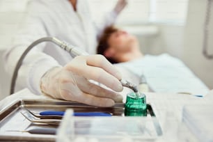 a person in a hospital bed with a green bottle