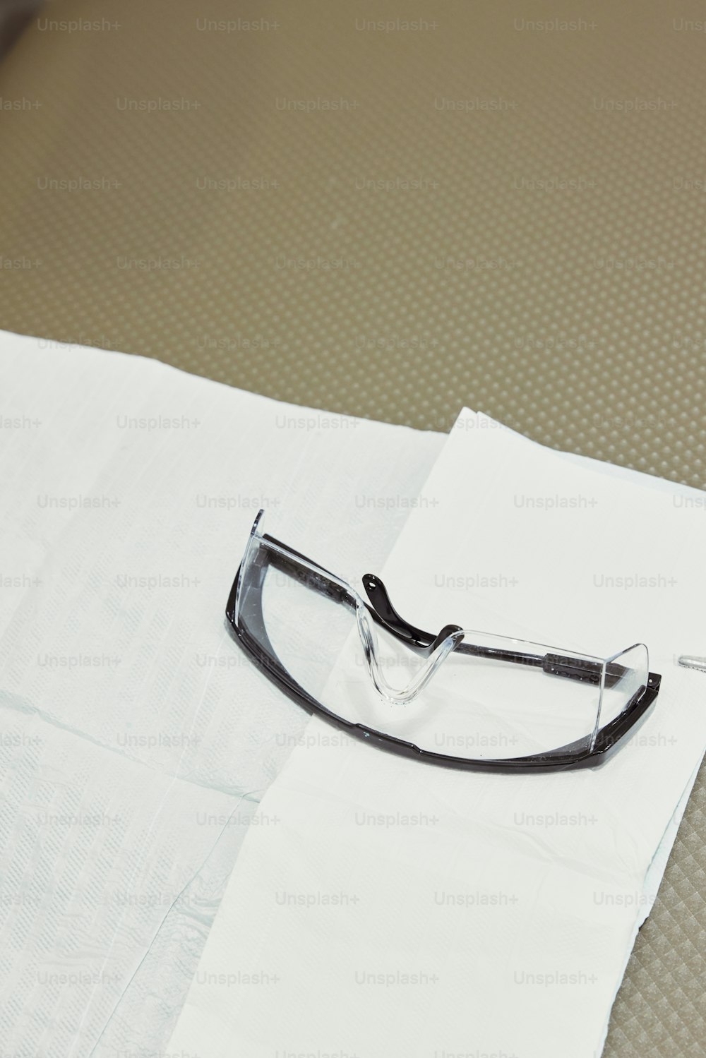 a pair of glasses sitting on top of a white napkin