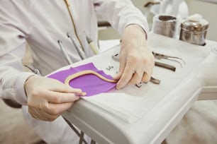 a person in a white coat is cutting a piece of paper