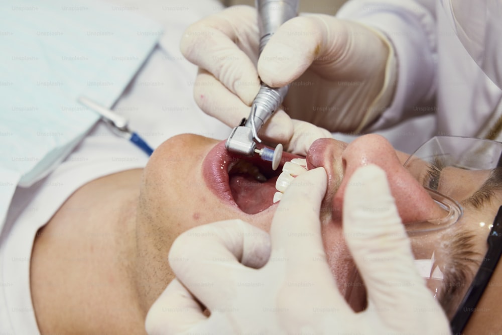 um homem que verifica seus dentes por um dentista