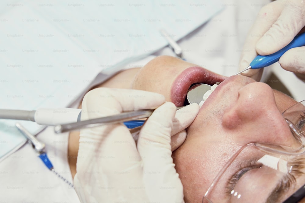 a woman getting her teeth checked by a dentist