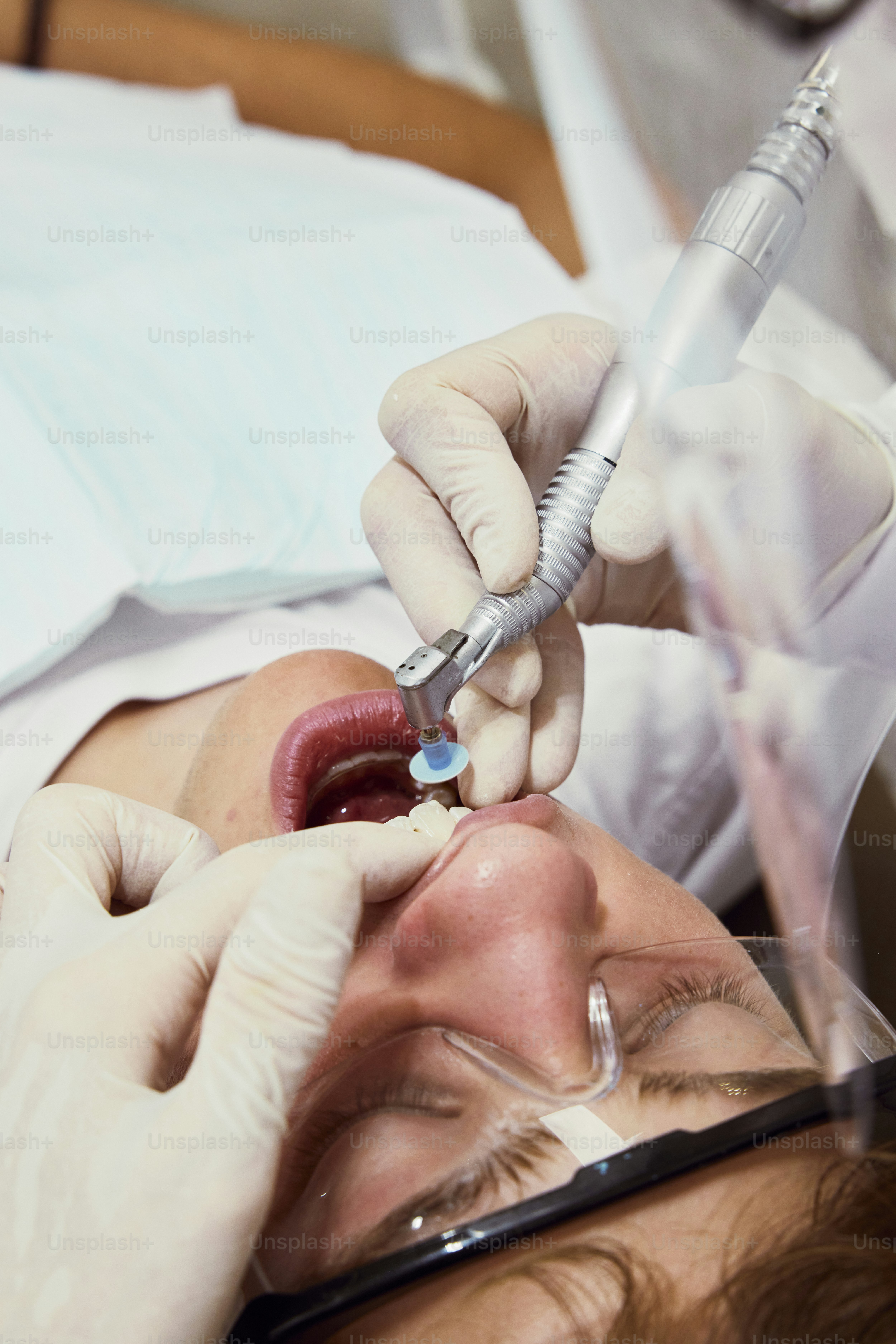 a woman getting her teeth checked by a dentist