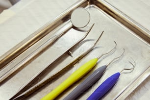 a metal tray with three different tools on it
