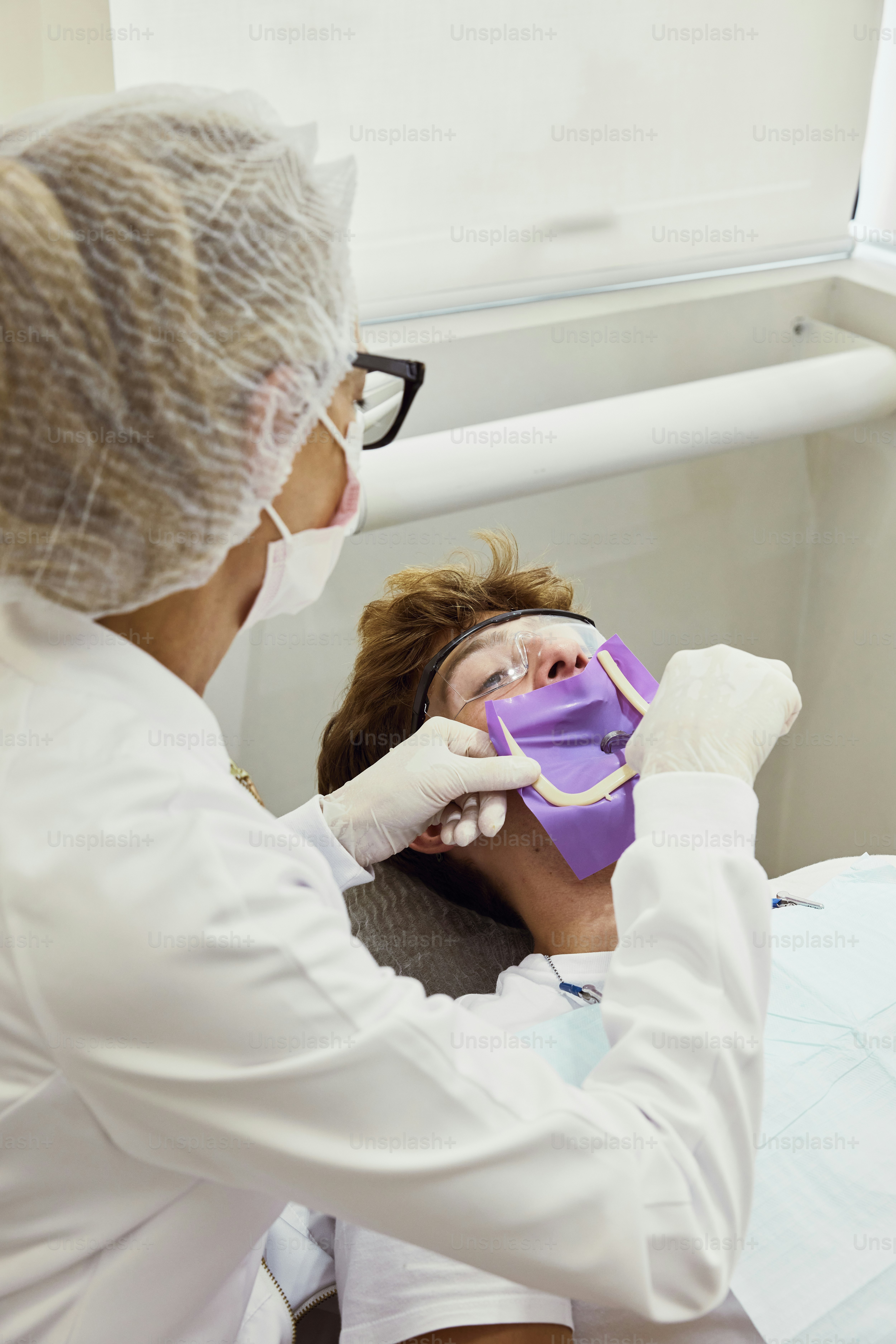 a woman getting her teeth checked by a dentist
