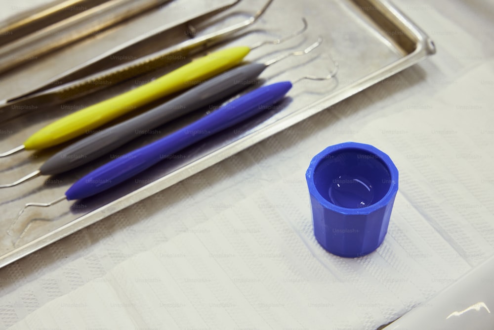una tazza blu seduta sopra un vassoio di metallo