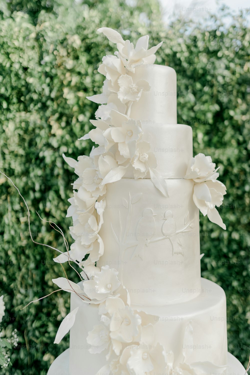 Un pastel de bodas blanco con flores blancas en la parte superior