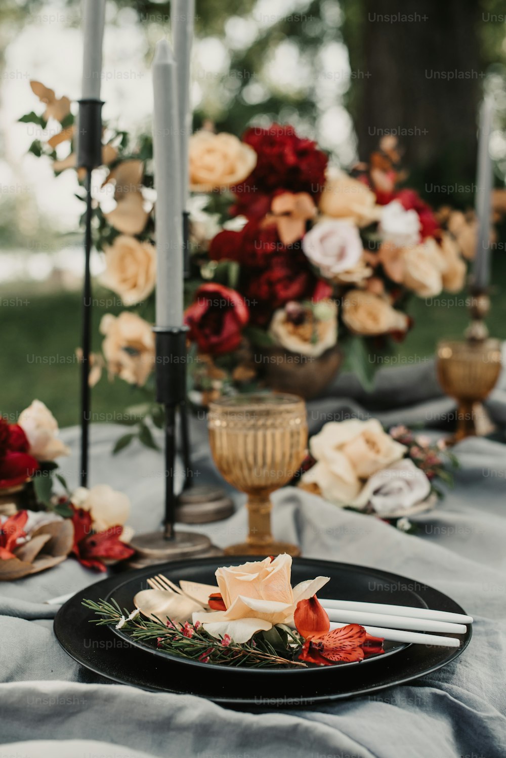 ein schwarzer Teller mit Blumen und Kerzen