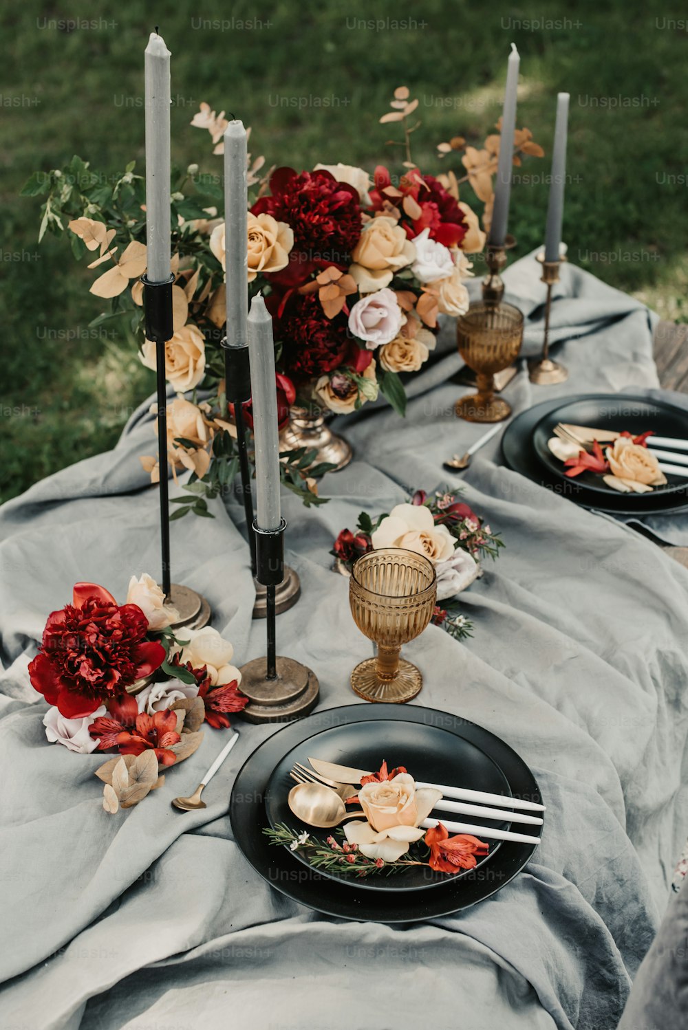 a table topped with black plates covered in flowers