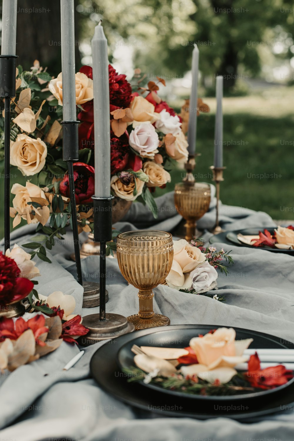 a table topped with a black plate covered in flowers