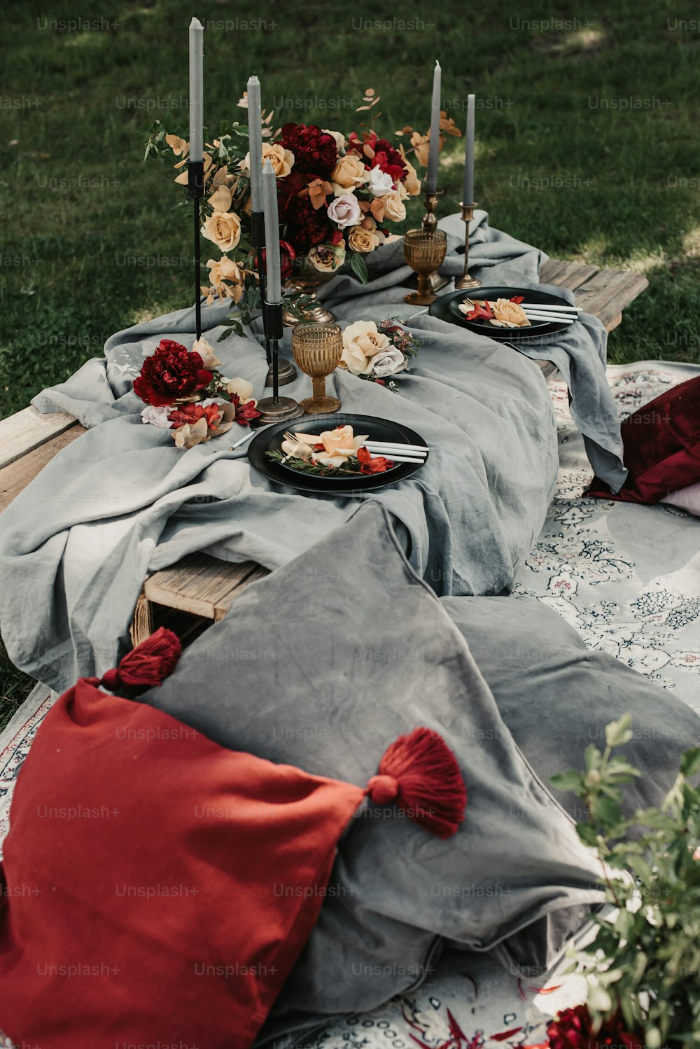 ein Tisch mit einer mit Stoff bedeckten Tischdecke und Kerzen darauf