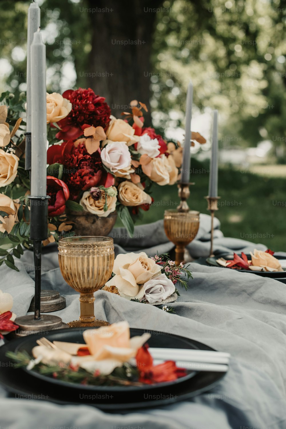 a table topped with a black plate covered in flowers