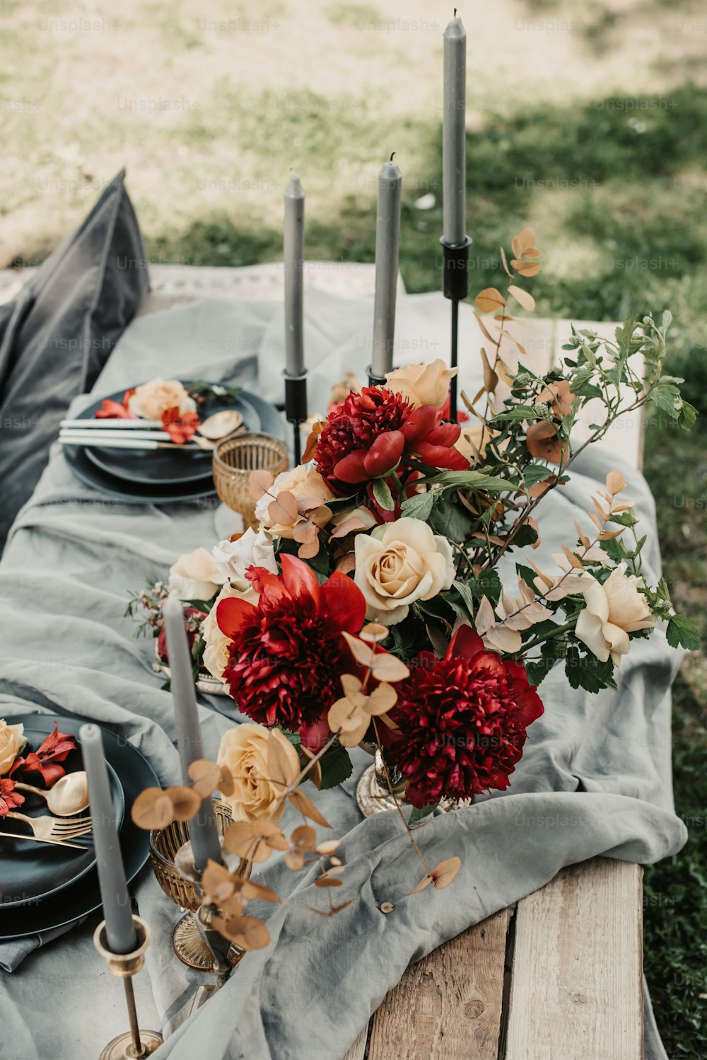 ein Holztisch mit Blumen und Kerzen
