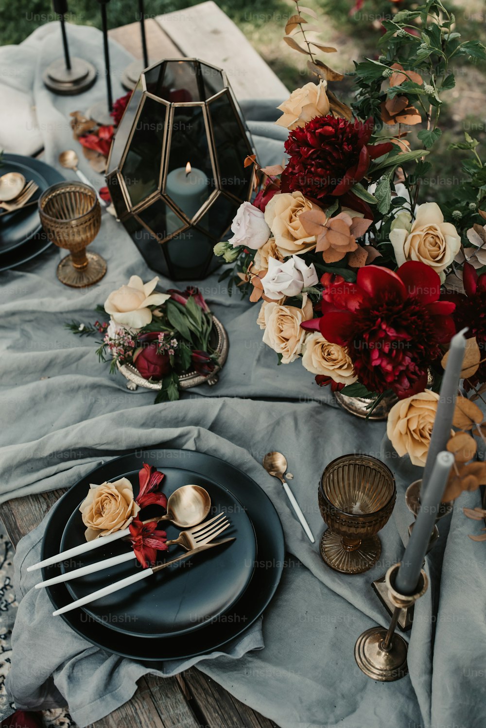 ein Tisch mit Tellern und eine Vase voller Blumen