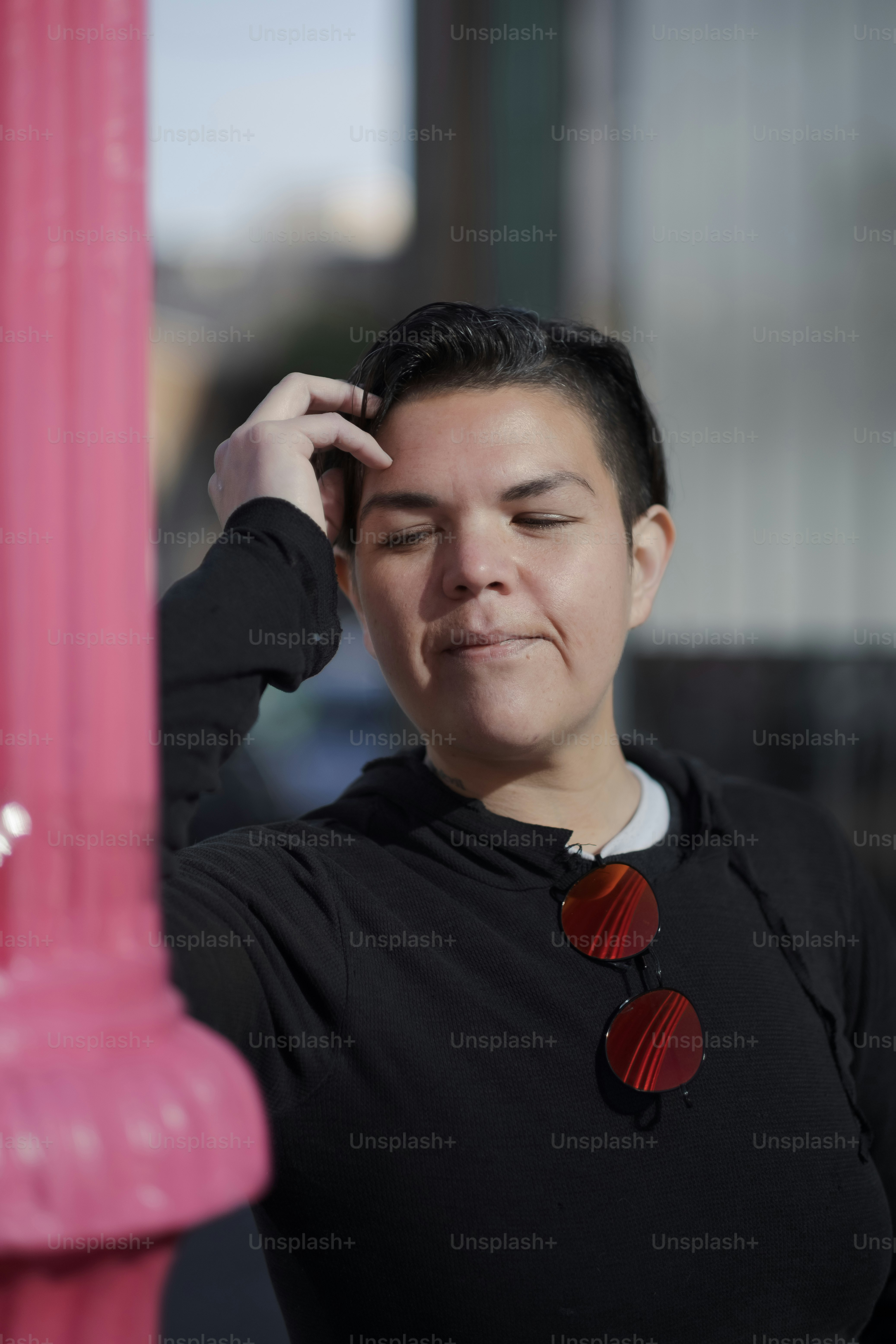 a woman standing next to a pink pole