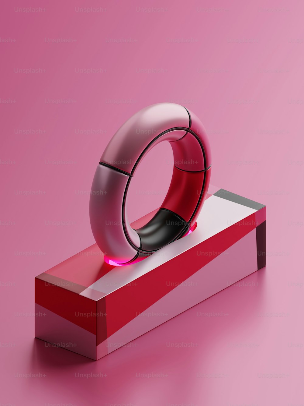 um objeto vermelho e branco em uma superfície rosa