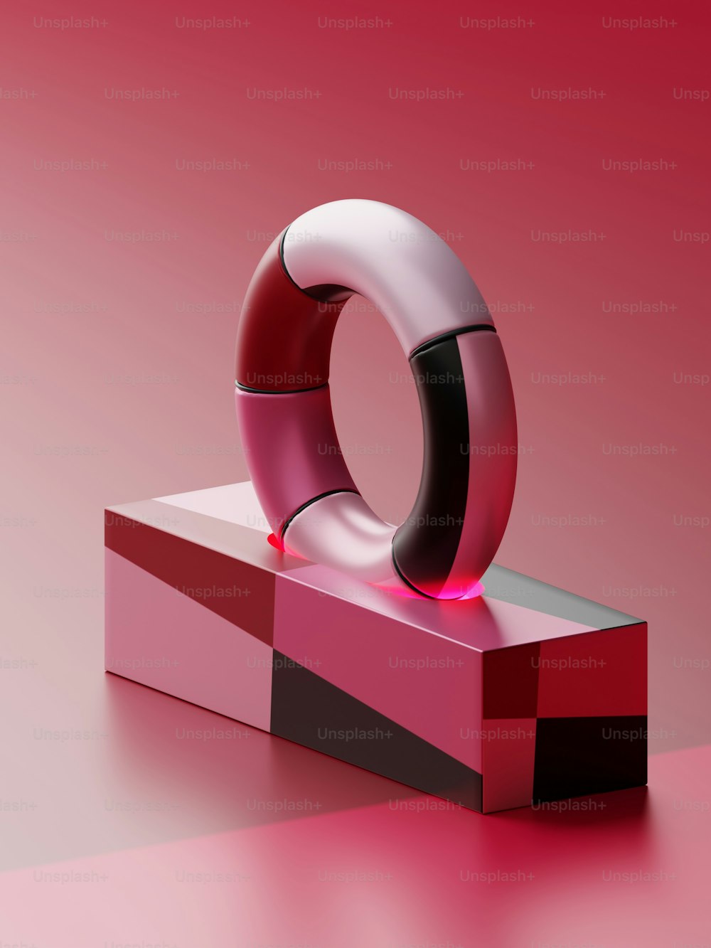 a red and black object on a pink surface