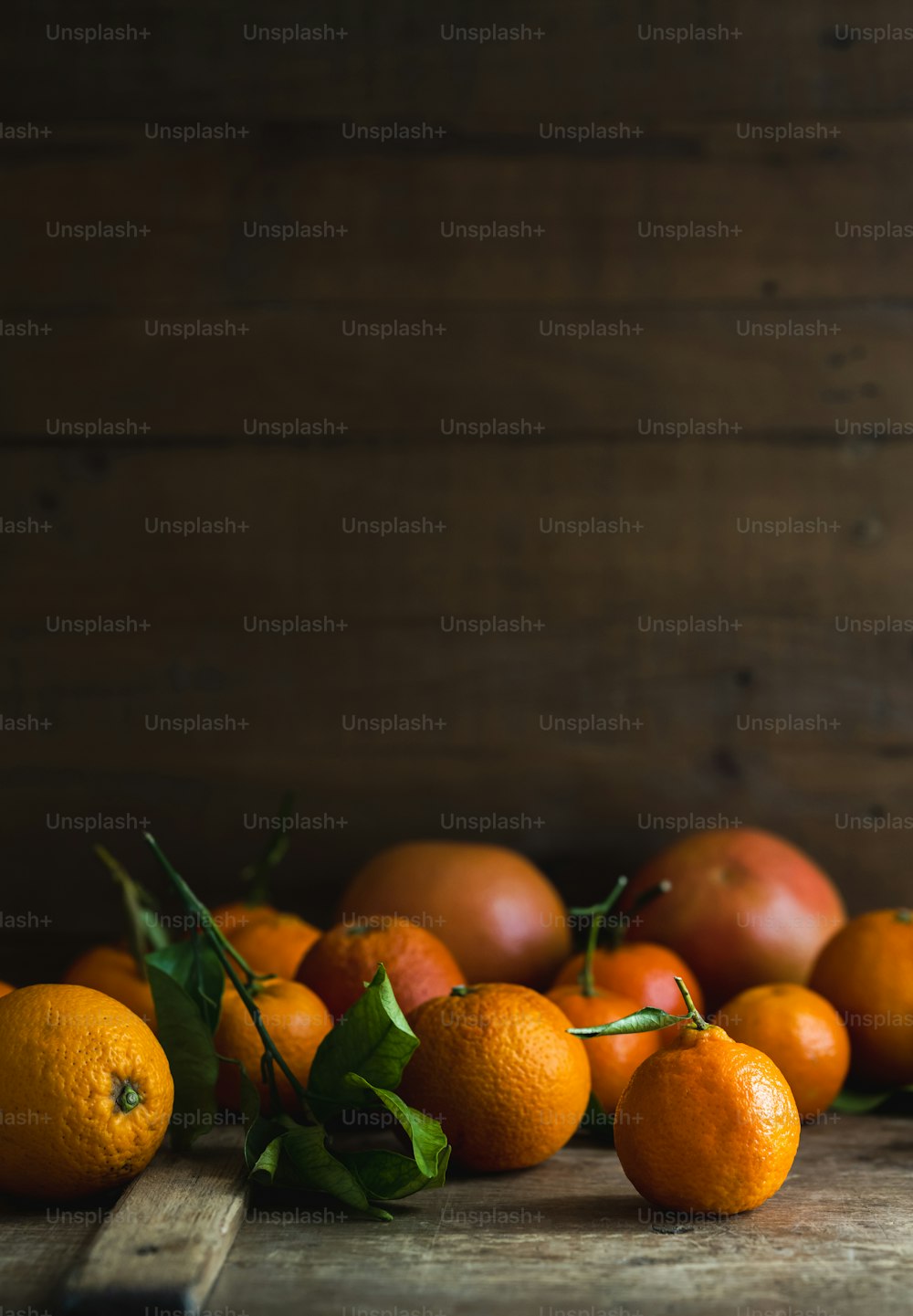 木製のテーブルの上に座っているオレンジの山
