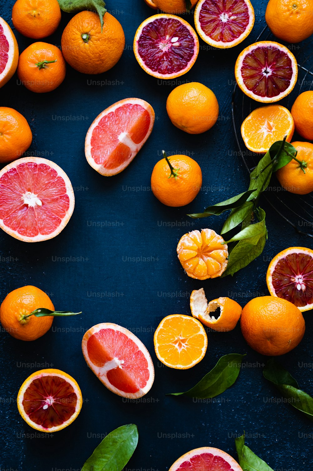 eine Gruppe von Grapefruits und Orangen auf einer blauen Oberfläche