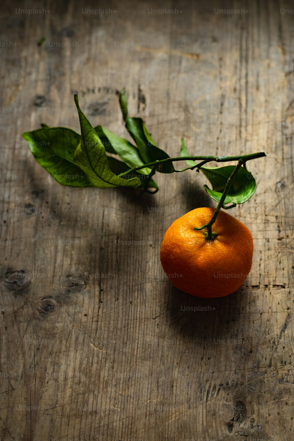 eine Orange, die auf einem Holztisch sitzt