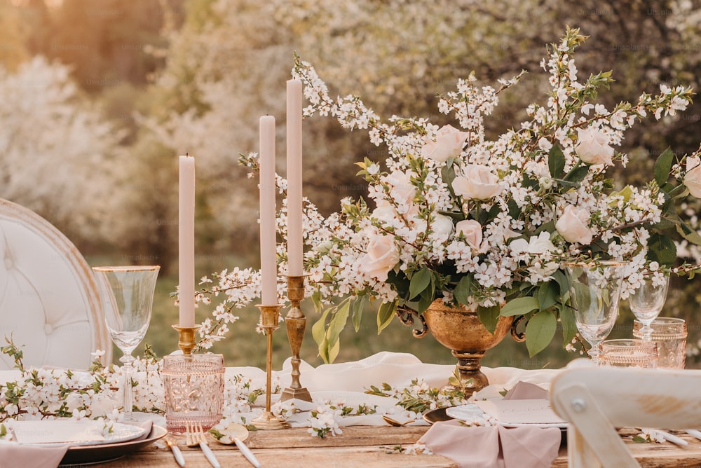 une table avec un vase de fleurs et de bougies