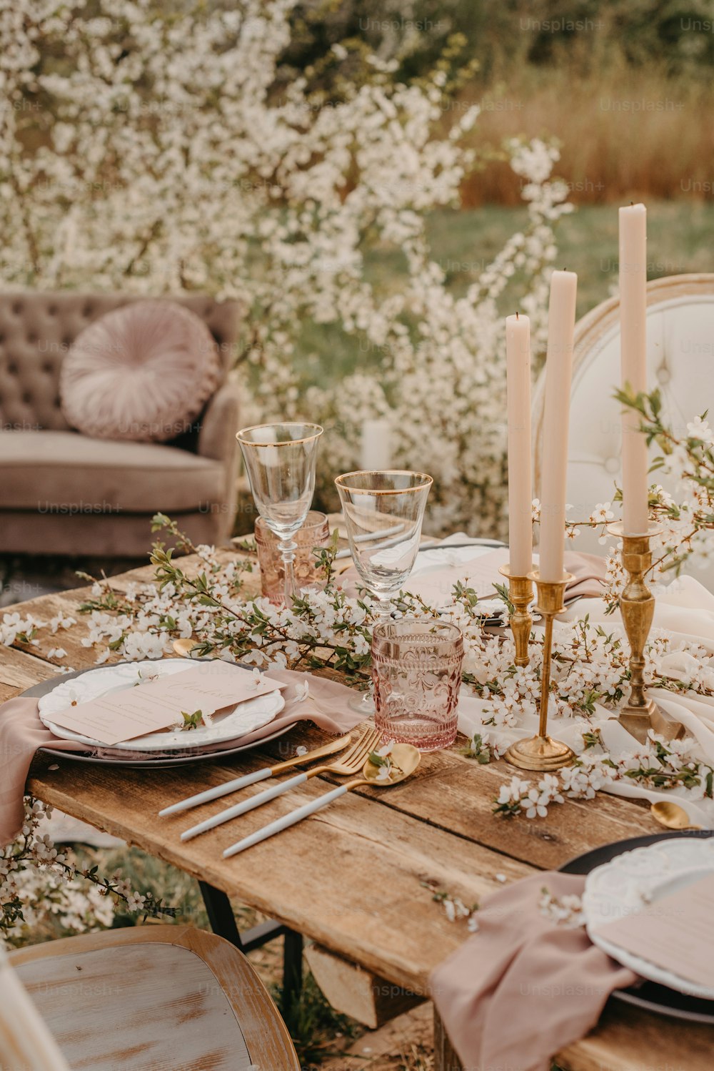 una mesa de madera cubierta con platos y velas