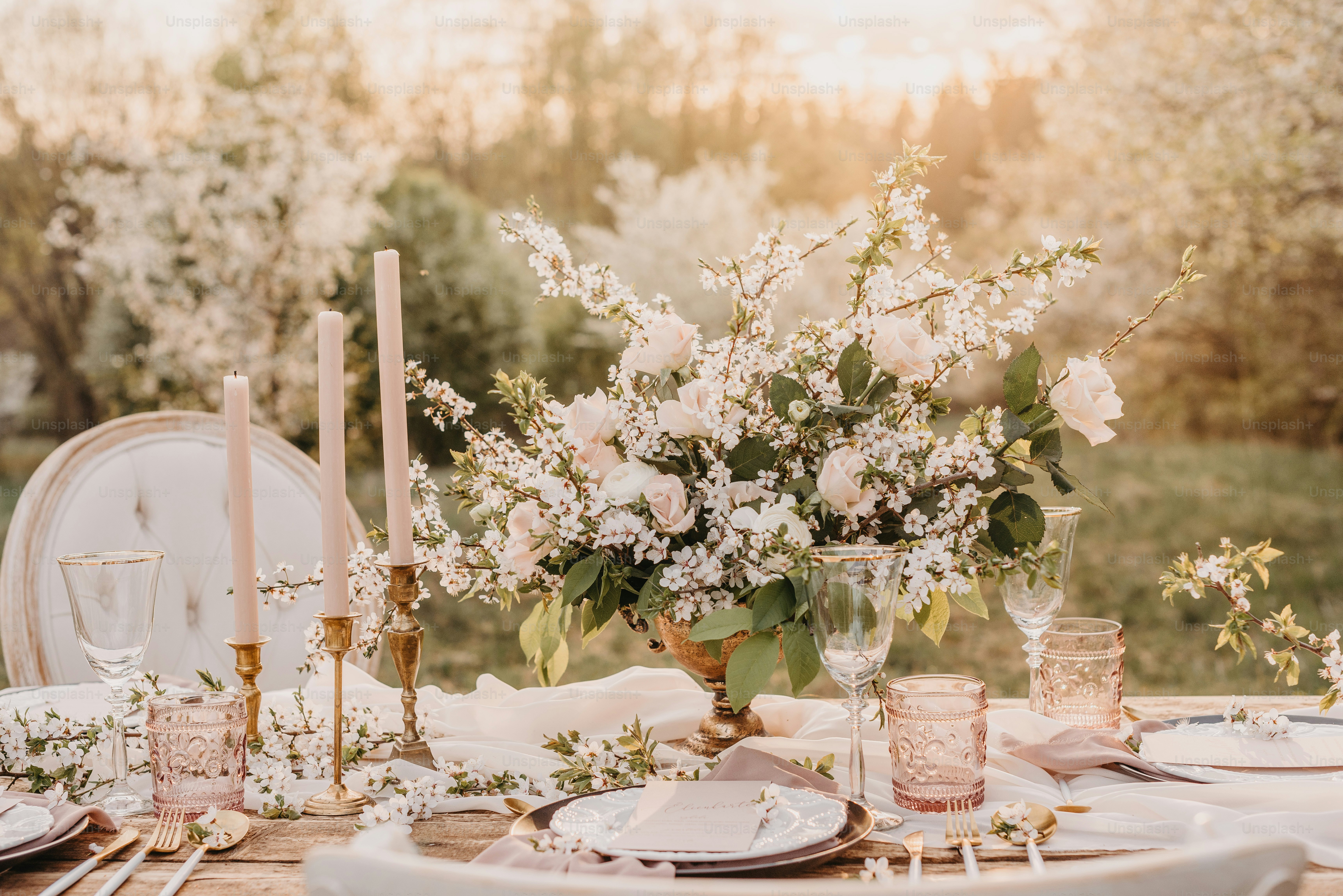 a table with a vase of flowers and candles on it