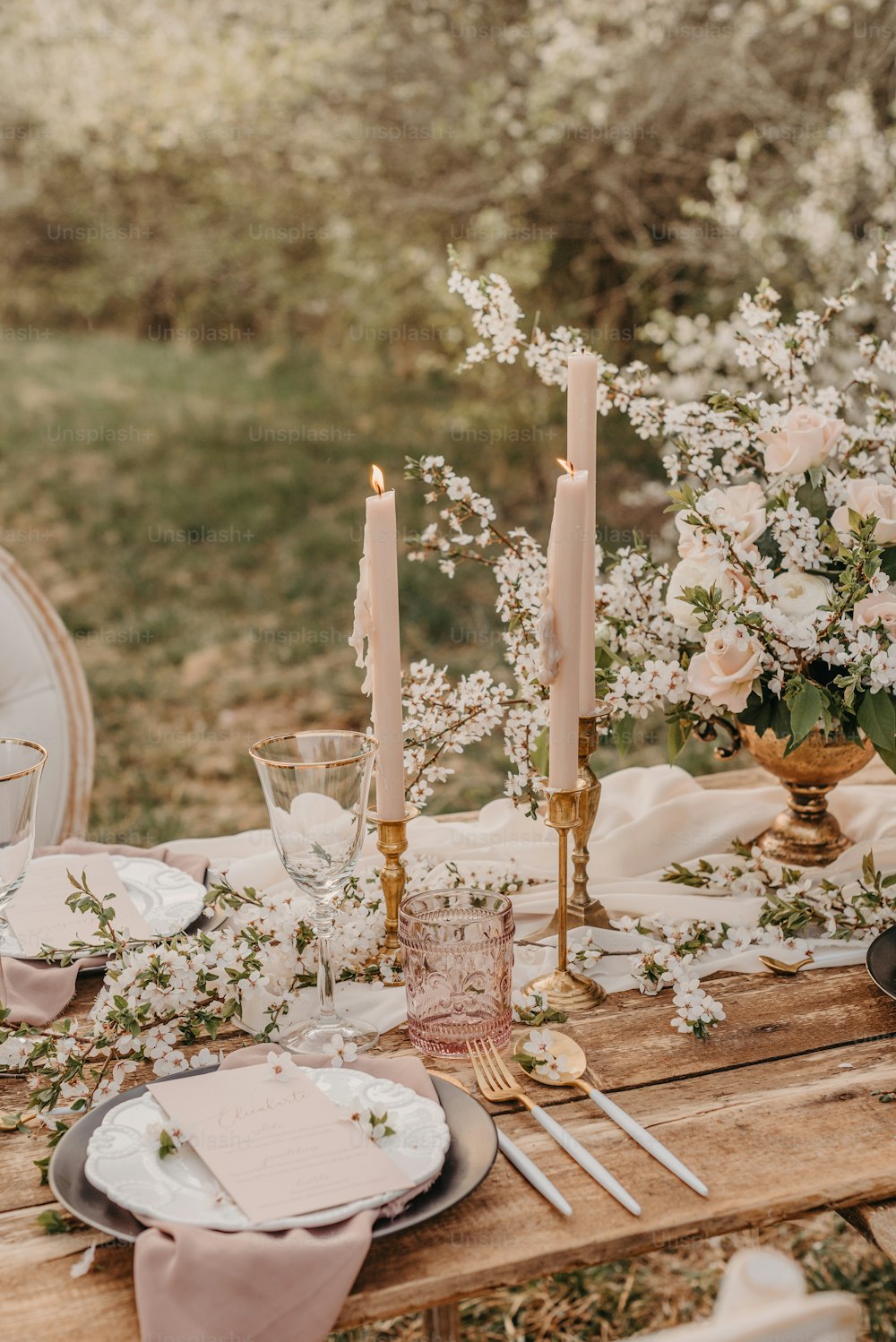a wooden table topped with plates and candles