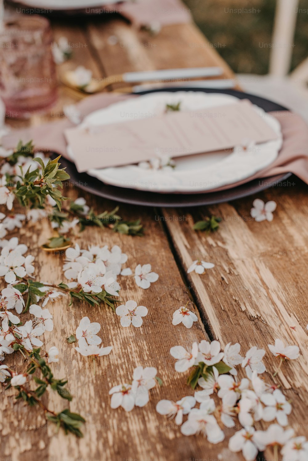 uma mesa de madeira coberta com pratos e flores