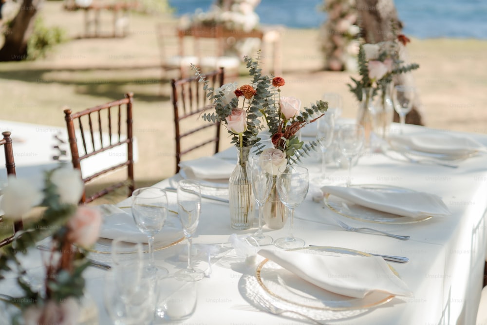 Una mesa puesta para una boda con flores en un jarrón