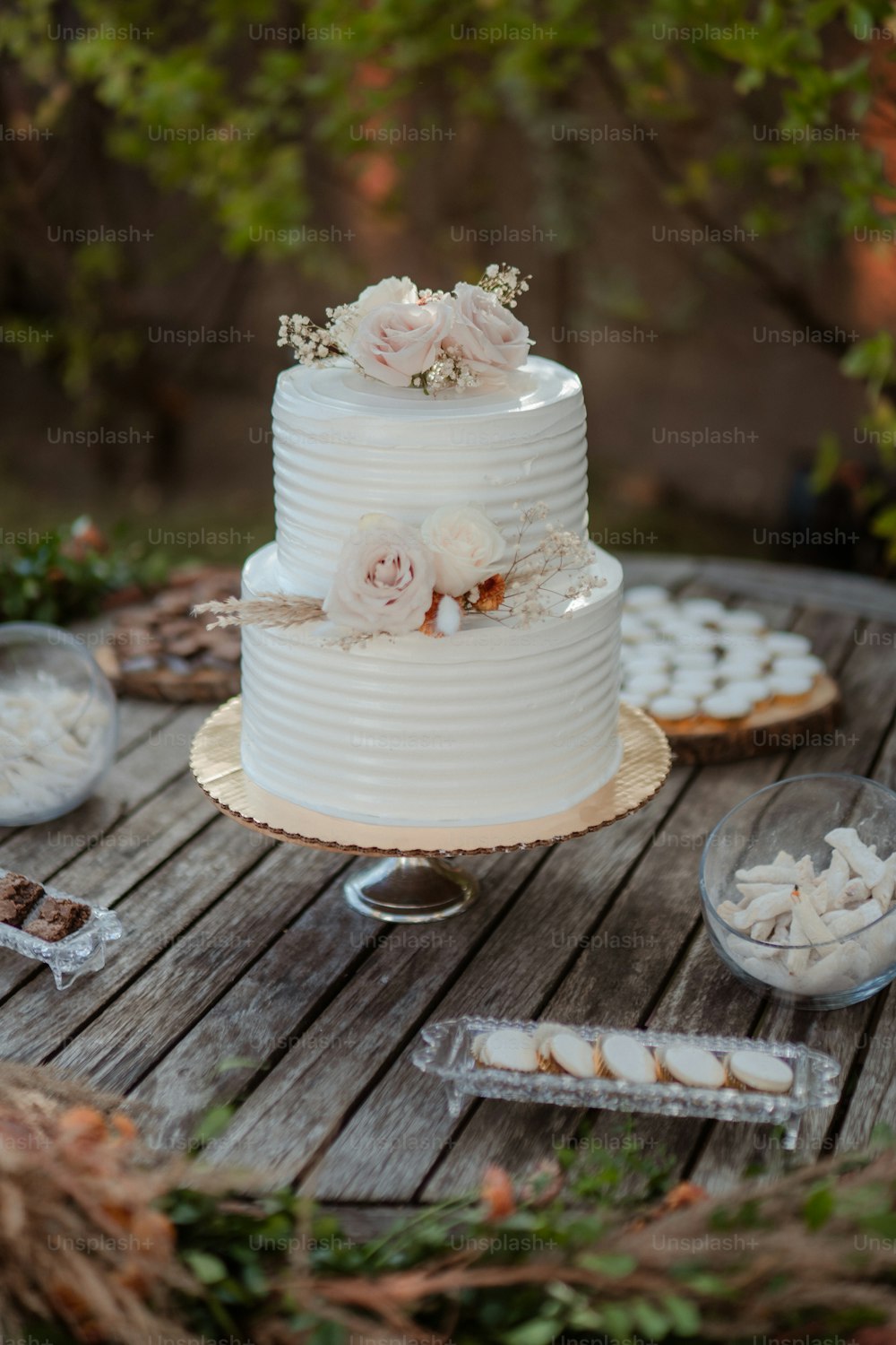 um bolo de casamento branco sentado em cima de uma mesa de madeira