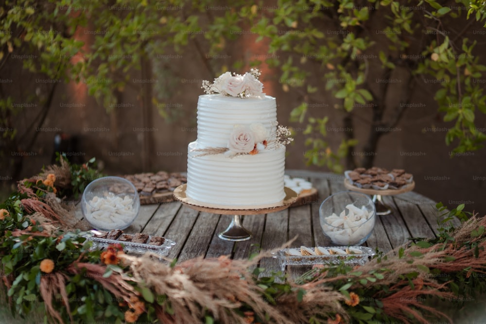 a white wedding cake sitting on top of a wooden table