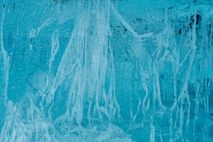 a man standing in front of a blue wall covered in icicles