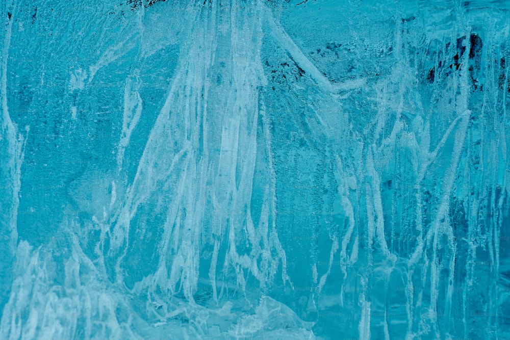 Ein Mann steht vor einer blauen, mit Eiszapfen bedeckten Wand