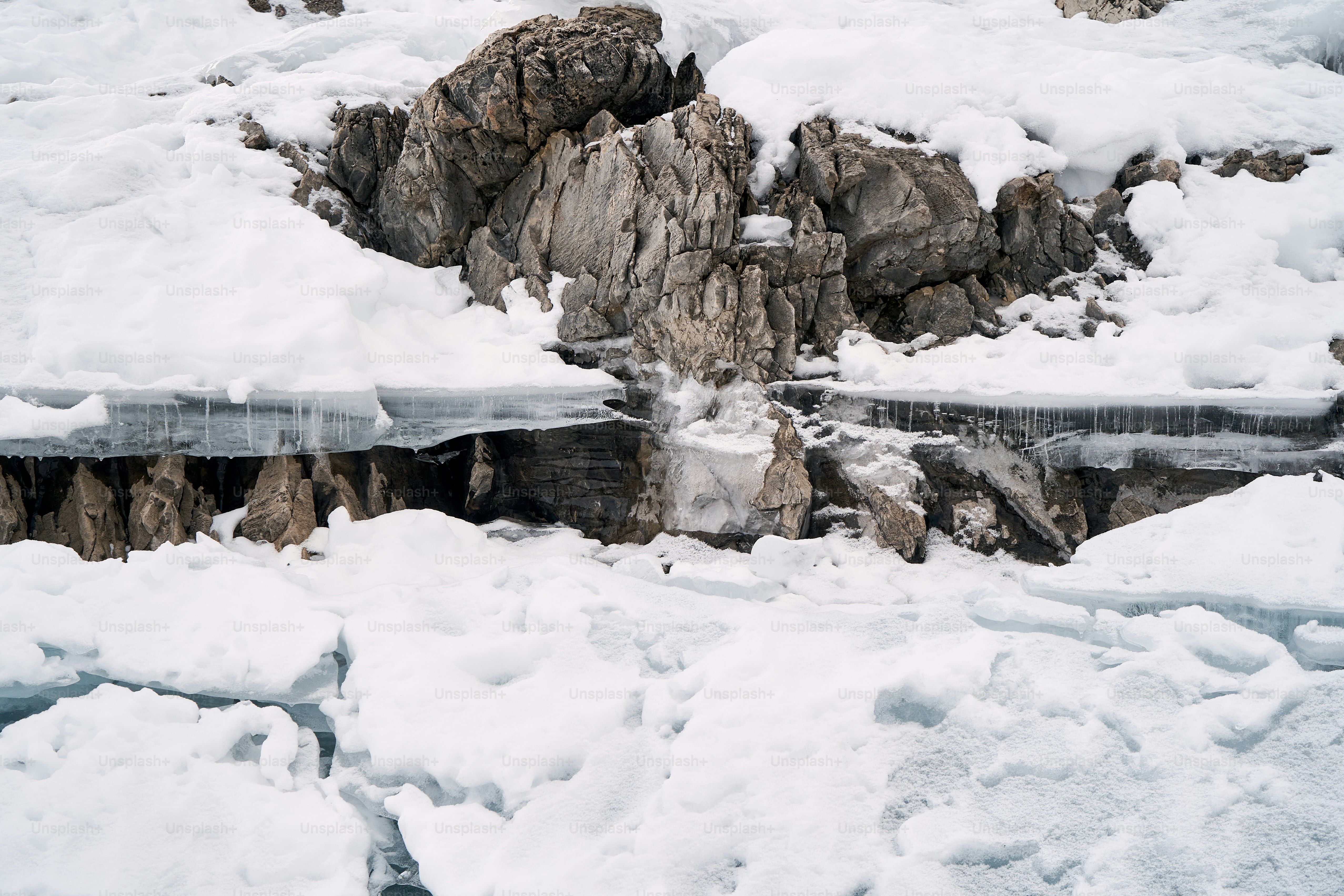 a snow covered mountain side with a waterfall