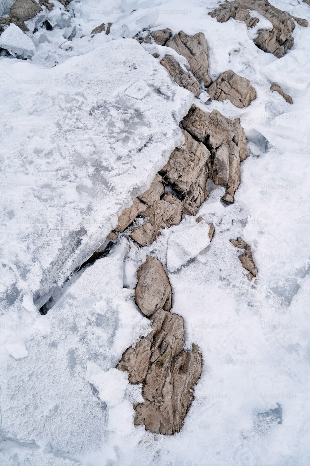 a snow covered area with rocks and snow